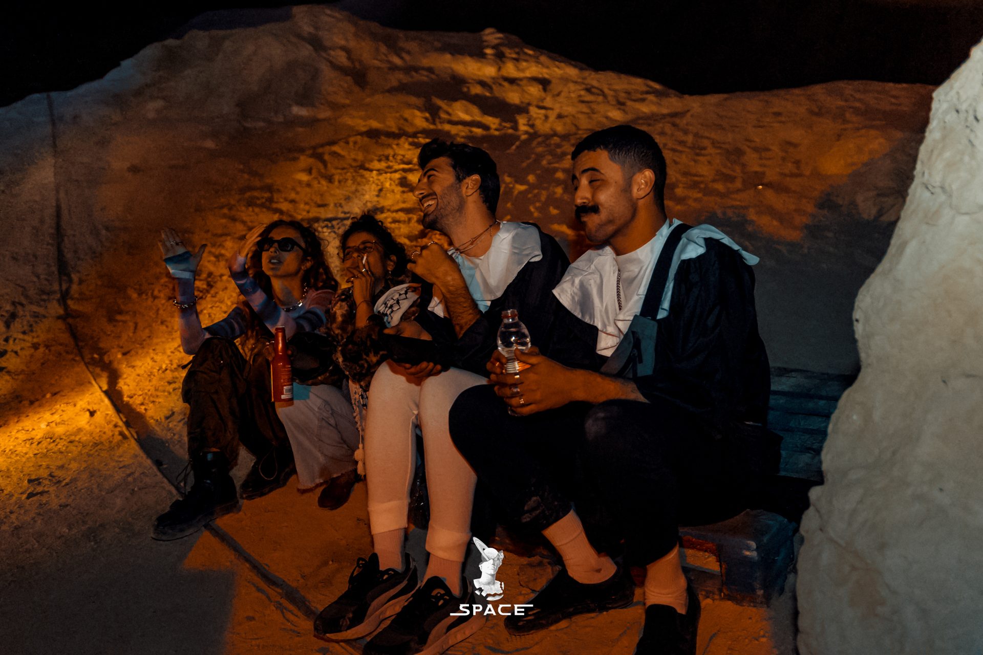 Friends gathered inside a lit canyon at a SPACE event
